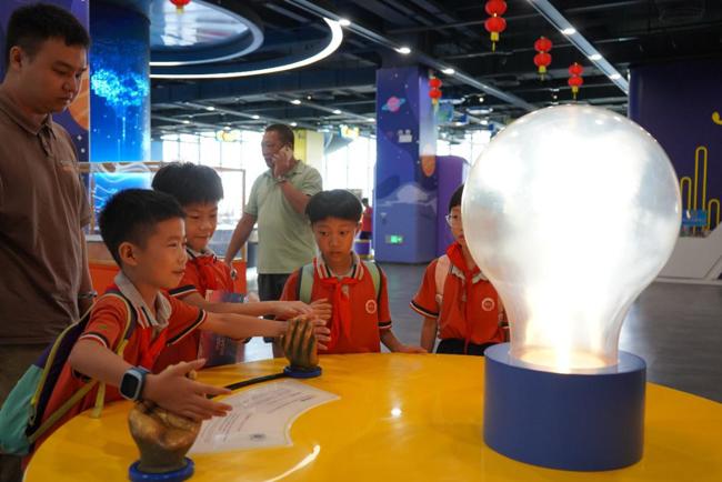 小朋友在科技馆体验“人体发电” 小朋友在科技馆体验“人体发电”